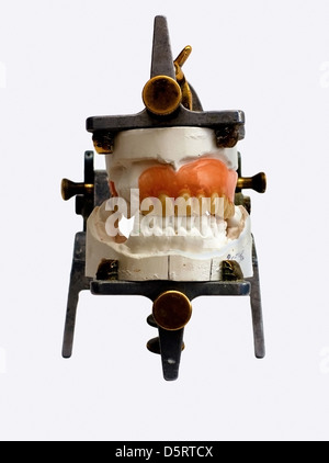 Prothesen, die isoliert auf einem weißen Hintergrund auf grau metallic Artikulator für Zahntechniker Stockfoto