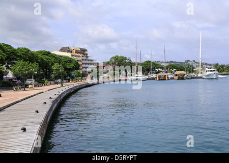 Die Waterfront Promenade Kurven in Richtung Boote vertäut im Hafen von Papeete, Tahiti. Stockfoto