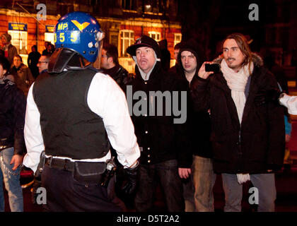 London, UK. 8. April 2013. ein [Rotester argumentiert mit einem Polizeibeamten, wie Celbrations sauer und Demonstranten die Straße blockierten. Polizei mit Helmen wurden Flaschen beworfen. Stockfoto