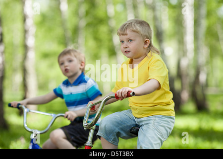 niedlichen Kinder ihr Fahrrad im park Stockfoto