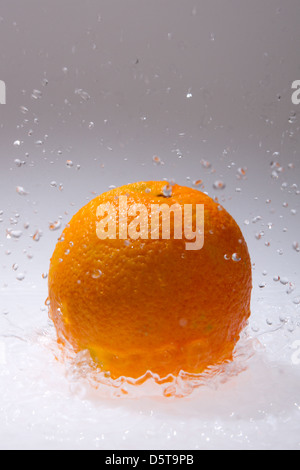 Orange Früchte und spritziges Wasser isoliert auf weiss Stockfoto