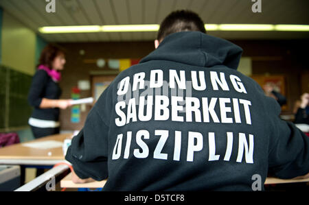 Ein Schüler besucht eine Englischlektion an einem "Realschule"-Gymnasium trägt einen Pullover mit den Worten, dass "Ordnung, Sauberkeit, Disziplin" auf dem Rücken in Hannover, Deutschland, 21. November 2012 gedruckt. Die Schule bekam einen guten Bericht während der letzten Schulinspektion in Niedersachsen, die rund 3000 Schulen in Niedersachsen jährlich bewertet. Foto: Julian Stratenschulte Stockfoto