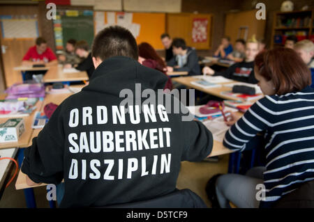 Ein Schüler besucht eine Englischlektion an einem "Realschule"-Gymnasium trägt einen Pullover mit den Worten, dass "Ordnung, Sauberkeit, Disziplin" auf dem Rücken in Hannover, Deutschland, 21. November 2012 gedruckt. Die Schule bekam einen guten Bericht während der letzten Schulinspektion in Niedersachsen, die rund 3000 Schulen in Niedersachsen jährlich bewertet. Foto: Julian Stratenschulte Stockfoto