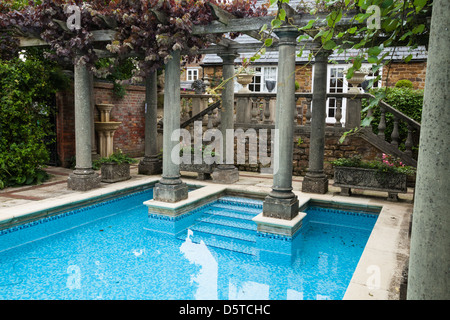 Schwimmbad mit klassischen Säulen und Mosaikfliesen im Haddonstone Schaugärten, East Haddon, Northamptonshire, England Stockfoto