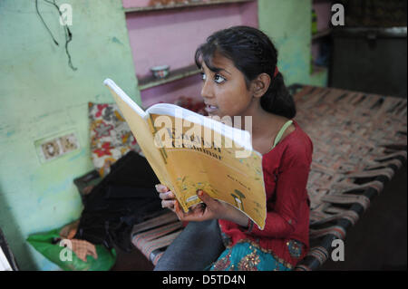 Sechste-Grader Amreen macht ihre englischen Hausaufgaben bei ihr zu Hause in einer armen Gegend von Jaipur, Indien, 15. November 2012. Ihre 45 Jahre alte Mutter, Shayda Bano, hat vier Kinder und bekam Geld von SOS-Kinderdorf Dörfer von Jaipur zu kaufen, eine Nähmaschine und Gewebe, das sie für ihre Familie Geld verdienen kann. Im Moment kümmern sich die SOS-Kinderdorf Dörfer von Jaipur 99 Fälle von f Stockfoto