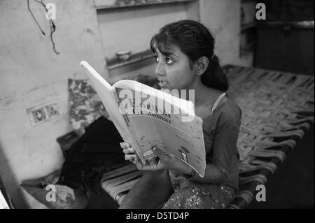 Sechste-Grader Amreen macht ihre englischen Hausaufgaben bei ihr zu Hause in einer armen Gegend von Jaipur, Indien, 15. November 2012. Ihre 45 Jahre alte Mutter, Shayda Bano, hat vier Kinder und bekam Geld von SOS-Kinderdorf Dörfer von Jaipur zu kaufen, eine Nähmaschine und Gewebe, das sie für ihre Familie Geld verdienen kann. Im Moment kümmern sich die SOS-Kinderdorf Dörfer von Jaipur 99 Fälle von f Stockfoto