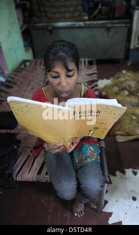 Sechste-Grader Amreen macht ihre englischen Hausaufgaben bei ihr zu Hause in einer armen Gegend von Jaipur, Indien, 15. November 2012. Ihre 45 Jahre alte Mutter, Shayda Bano, hat vier Kinder und bekam Geld von SOS-Kinderdorf Dörfer von Jaipur zu kaufen, eine Nähmaschine und Gewebe, das sie für ihre Familie Geld verdienen kann. Im Moment kümmern sich die SOS-Kinderdorf Dörfer von Jaipur 99 Fälle von f Stockfoto