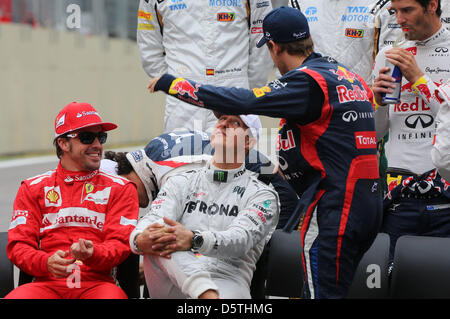 Deutsche Formel1 Rennfahrer Michael Schumacher (C) of Mercedes AMG, spanische Formel1-Fahrer Fernando Alonso Ferrari (L) und deutscher Formel-1-Fahrer Sebastian Vettel (2-R) von Red Bull beim offiziellen Fototermin mit allen Treibern vor dem Start auf dem Autodromo Jose Carlos Pace in Sao Paulo, Brasilien, 25. November 2012 gesehen. Die Formel 1 Grand Prix von Brasilien werden die endgültigen r Stockfoto