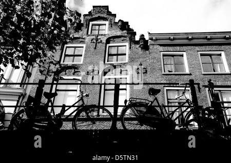 Fahrräder, die auf einer Brücke vor einem alten Kanalhaus geparkt, Oude Gracht, Utrecht, Niederlande Stockfoto