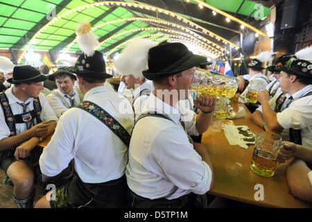 Besucher in bayerischer Tracht sitzen in einem Zelt auf dem 179. Oktoberfest in München, 23. September 2012 gekleidet. Das Oktoberfest ist das weltweit größte Volksfest und das diesjährige Oktoberfest findet vom 22. September bis 7. Oktober 2012. Foto: Andreas Gebert Stockfoto