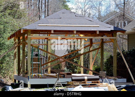 Konstruieren einen überdachte Holzterrasse-Bereich auf der Rückseite von einem bestehenden Haus. Der Bodenbelag ist ein zusammengesetztes Material. Stockfoto