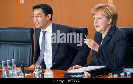 Deutsche Bundeskanzlerin Angela Merkel (CDU) im Gespräch mit Vizekanzler und Bundesminister für Wirtschaft Philipp Rösler (FDP) zu Beginn der Kabinettssitzung im Bundeskanzleramt in Berlin, Deutschland, 26. September 2012. Das Kabinett wird sich mit der Umsetzung der Fiskalpakt in Deutschland und den 2012-Bericht über den aktuellen Stand der deutschen Einheit, unter o beschäftigen. Stockfoto