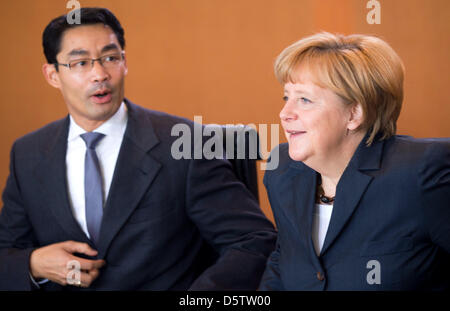 Deutsche Bundeskanzlerin Angela Merkel (CDU) im Gespräch mit Vizekanzler und Bundesminister für Wirtschaft Philipp Rösler (FDP) zu Beginn der Kabinettssitzung im Bundeskanzleramt in Berlin, Deutschland, 26. September 2012. Das Kabinett wird sich mit der Umsetzung der Fiskalpakt in Deutschland und den 2012-Bericht über den aktuellen Stand der deutschen Einheit, unter o beschäftigen. Stockfoto