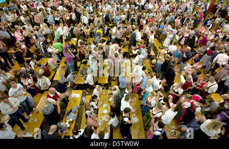 Besucher des Oktoberfestes wiegen die Musik an ihren Tischen Bier in München, Deutschland, 25. September 2012. Das Oktoberfest gilt als die weltweit größte Messe und findet vom 22. September bis 7. Oktober 2012. Foto: PETER KNEFFEL Stockfoto