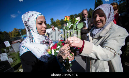 Frauen verteilen Blumen außerhalb der Sehitlik Moschee am Columbiadamm in Berlin, Deutschland, 3. Oktober 2012. 18 Moscheen haben ihre Türen für Besucher zum Tag der deutschen Einheit geöffnet. Foto: HANNIBAL Stockfoto