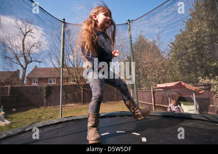 5 Jahre altes Mädchen auf einem Garten Trampolin springen Stockfoto