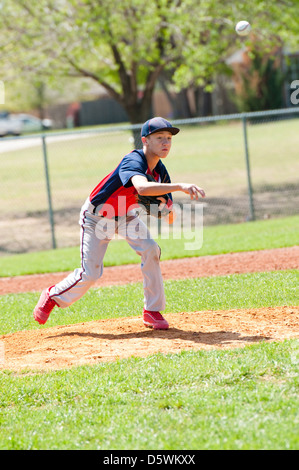 Teen Baseball Krug nach dem Wurf in den Teig mit dem Ball in der Luft. Stockfoto