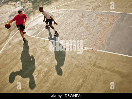 Männer spielen Basketball auf Platz Stockfoto