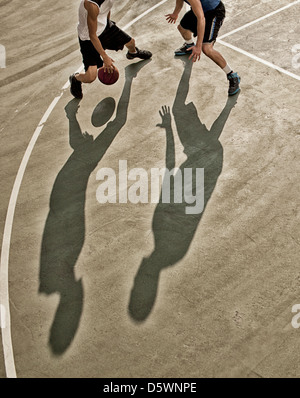 Männer spielen Basketball auf Platz Stockfoto