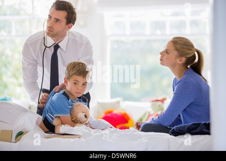 Arzt anhören des jungen Herzschlag auf Hausbesuch Stockfoto