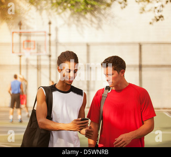 Männer sprechen auf Basketballplatz Stockfoto