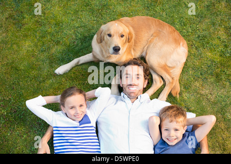 Familie mit Hund auf Wiese entspannen Stockfoto