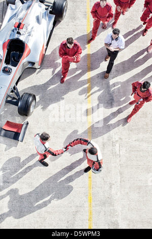 Händeschütteln auf Track Racer Stockfoto