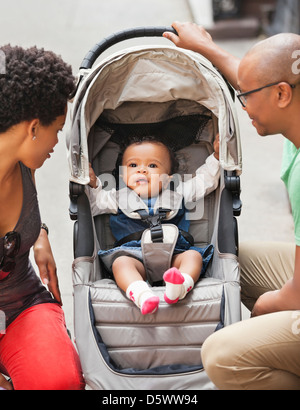 Eltern mit Baby im Kinderwagen auf Stadtstraße Stockfoto