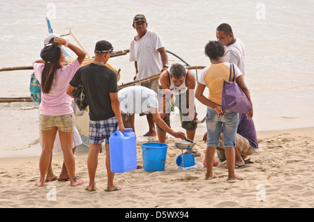 Asiatische philippinischen Fischer wiegt und verkauft seine frischen Fang direkt am Strand – White Beach, Puerto Galera, Philippinen Stockfoto