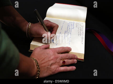 US-Diplomaten und Service-Mitglieder unterzeichnen ein Kondolenzbuch während einer Trauerfeier für Anne Smedinghoff an der US-Botschaft 8. April 2013 in Kabul, Afghanistan. Smedinghoff starb in einen Aufständischen Angriff am 6. April unterwegs, um Bücher zu einer Schule in Qalat, Provinz Zabul zu spenden. Stockfoto