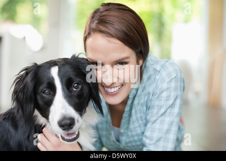 Lächelnde Frau Petting Hund drinnen Stockfoto