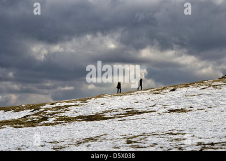 Bild von zwei Menschen, die zu Fuß im Schnee in Bradgate Country Park, Leicestershire, England, UK Stockfoto