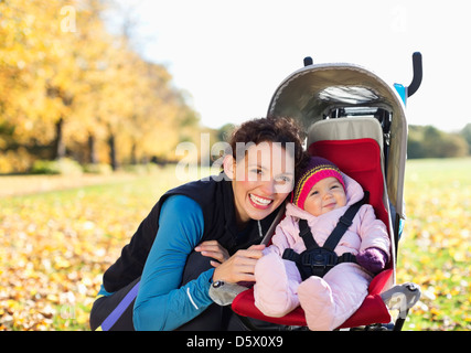 Frau mit Baby im Kinderwagen lächelnd Stockfoto