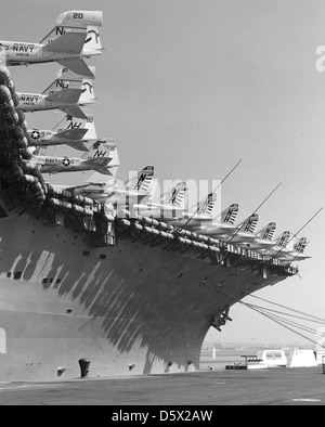 Tails der LTV A-7 Corsair II'', Grumman A-6 'Eindringling', und EA-6B "Prowler" hängen über der Seite der USS KITTY HAWK (CVA-63) während Sie pier Seite an NAS-North Island, Kalifornien gebunden ist. Stockfoto