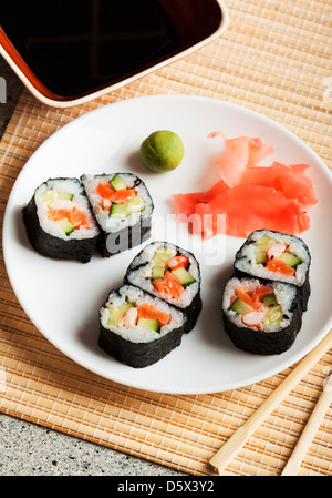 Köstliche Sushi-Rollen mit Stäbchen Stockfoto