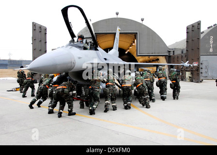 Flieger von der 79th Fighter Squadron drücken Sie eine F-16 Fighting Falcon in einem Hangar 14.01.15 in Kunsan, Südkorea. Mehr als 300 Flieger und mehrere Flugzeuge aus der 79th Fighter Squadron von Shaw Air Force Base, S.C., sind in Südkorea als Luft des Geschwaders und Raum Expeditionary Force Bereitstellung unterstützen, Frieden und Stabilität in der pazifischen Region aufrechterhalten. (U.S. Air Force Foto/Senior Airman Steven R. Doty) Stockfoto