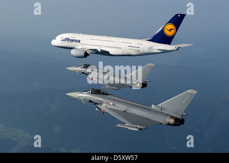 Ein Airbus A380 und ein österreichischer Eurofighter-Taifun fliegen am 22. August 2011 in Formation über die Steiermark. Die A380 ist ein Großraumflugzeug, während der Eurofighter Typhoon ein vielseitiges, hochagiles Kampfflugzeug der Österreichischen Luftwaffe ist. Stockfoto