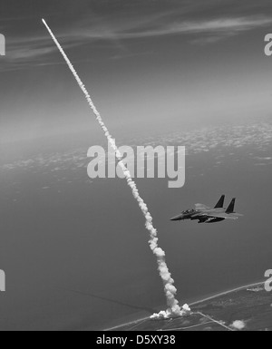 Oberstleutnant Gabriel Grün und Kapitän Zachary Nordsieck Patrouille der Himmel über Kennedy Space Center, Fla., in Trike eine McDonnell Douglas F-15E "Eagle" als das Space Shuttle "Atlantis" startet in den Raum für das letzte Mal. Stockfoto