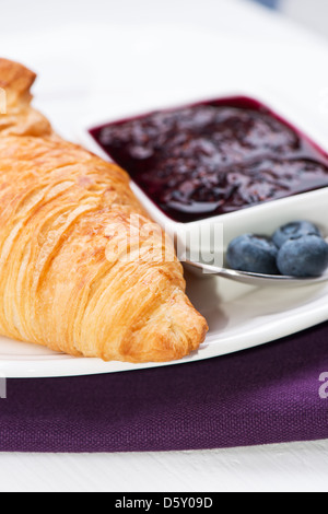 Croissant mit Blaubeeren Marmelade auf Platte Stockfoto