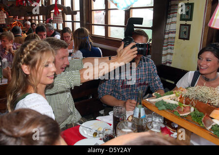 Bastian Schweinsteiger FC Bayern Muenchen nimmt Bilder neben seiner Freundin Sarah Brandner während des Oktoberfestes am Kaefer Wiesnschaenke Zelt am 7. Oktober 2012 in München. Sitzt am rechten seine Teamkollegen und Torwart Manuel Neuer (verdeckt von der Kamera) und seine Holland Kathrin. Foto: Alexander Hassenstein +++(c) Dpa - Bildfunk +++ Stockfoto