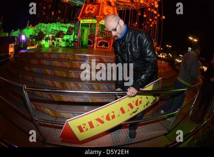 Ein Mann schließt sich den Eingang zu einem fliegenden Schwung nach dem Oktoberfest traditionelle Tabula Rasa in München, 7. Oktober 2012. Am 07 Oktober endete der 179. Oktoberfest offiziell. Foto: Felix Hoerhager Stockfoto