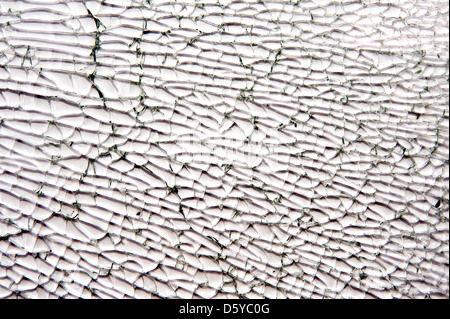 Kaputtes Autoglas auf weißem Hintergrund, rissige Autofenster. Stockfoto