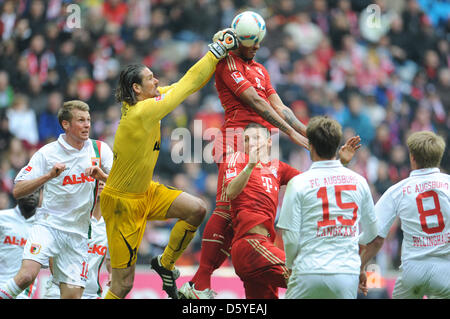 Augsburgs Torwart Simon Jentzsch (L) hält den Ball gegen Münchens Jerome Boateng (oben) und Bastian Schweinsteiger (C) während der Fußball-Bundesliga zwischen dem FC Bayern München und FC Augsburg in Allianz Arena in München, 7. April 2012 entsprechen. Foto: Andreas Gebert (Achtung: EMBARGO Bedingungen! Die DFL ermöglicht die weitere Nutzung der Bilder in IPTV, mobile s Stockfoto