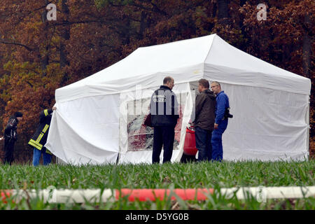 Polizist und Forensik-Spezialisten untersuchen einen Tatort in Hoerselgau, Deutschland, 24. Oktober 2012. Ein 69 Jahre alter Mann wurde Opfer eines Gewaltverbrechens. Die Staatsanwaltschaft kündigte in Erfurt, dass der Mann tot neben Hia Auto auf einer Landstrasse 23. Oktober 2012 gefunden wurde. Foto: CAROLIN LEMUTH Stockfoto