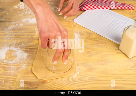 Weibliche Hände ausschneiden Kreise Bagels vorbereiten Stockfoto