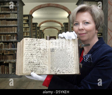 Bibliotheksdirektor Britta Klosterberg zeigt ein Leder gebundenes Buch von alten Schriften in den Franckeschen Stiftungen (Franke Stiftungen) in Halle, Deutschland, 26. Oktober 2012. Das Buch wurde in den Wänden eines Gästehauses seit 200 Jahren nach Einschätzung von Experten festgelegt, die das Volumen mit seinen zwölf Drucken rekonstruiert haben. Es umfasst elf Schriften von Martin Luther, darunter eine Predigt Stockfoto