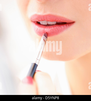 Frau Auftragen von Lippenstift mit Make-up Pinsel, Nahaufnahme