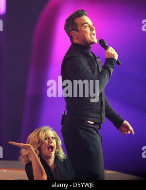 Deutsche Schauspielerin und TV-Host Barbara Schoeneberger (L) schlägt die Rückseite des britischen Sängers Robbie Williams während seines Auftritts in der ZDF-Spielshow "Wetten Das? (Wetten wollen...?) in der OVB-Arena in Bremen, Deutschland 3. November 2012. Foto: Ingo Wagner Stockfoto