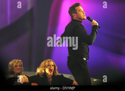 Deutsche Schauspielerin und TV-Host Barbara Schoeneberger (C) schlägt die Rückseite des britischen Sängers Robbie Williams während seines Auftritts in der ZDF-Spielshow "Wetten Das? (Wetten wollen...?) in der OVB-Arena in Bremen, Deutschland 3. November 2012. Foto: Ingo Wagner Stockfoto