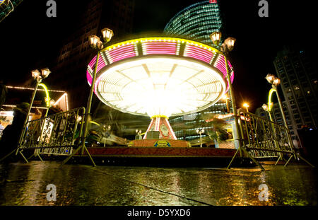 Besuchern stehen neben einem fliegenden Schwung am Potsdamer Platz in Berlin, Deutschland, 3. November 2012. Der Wintermarkt bietet Besuchern Wein, Bratwurst und Kettenkarusselle Glühwein. Foto: Kay Nietfeld Stockfoto